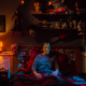 Scary Halloween night at home with pumpkins, candles and a horror movie on TV