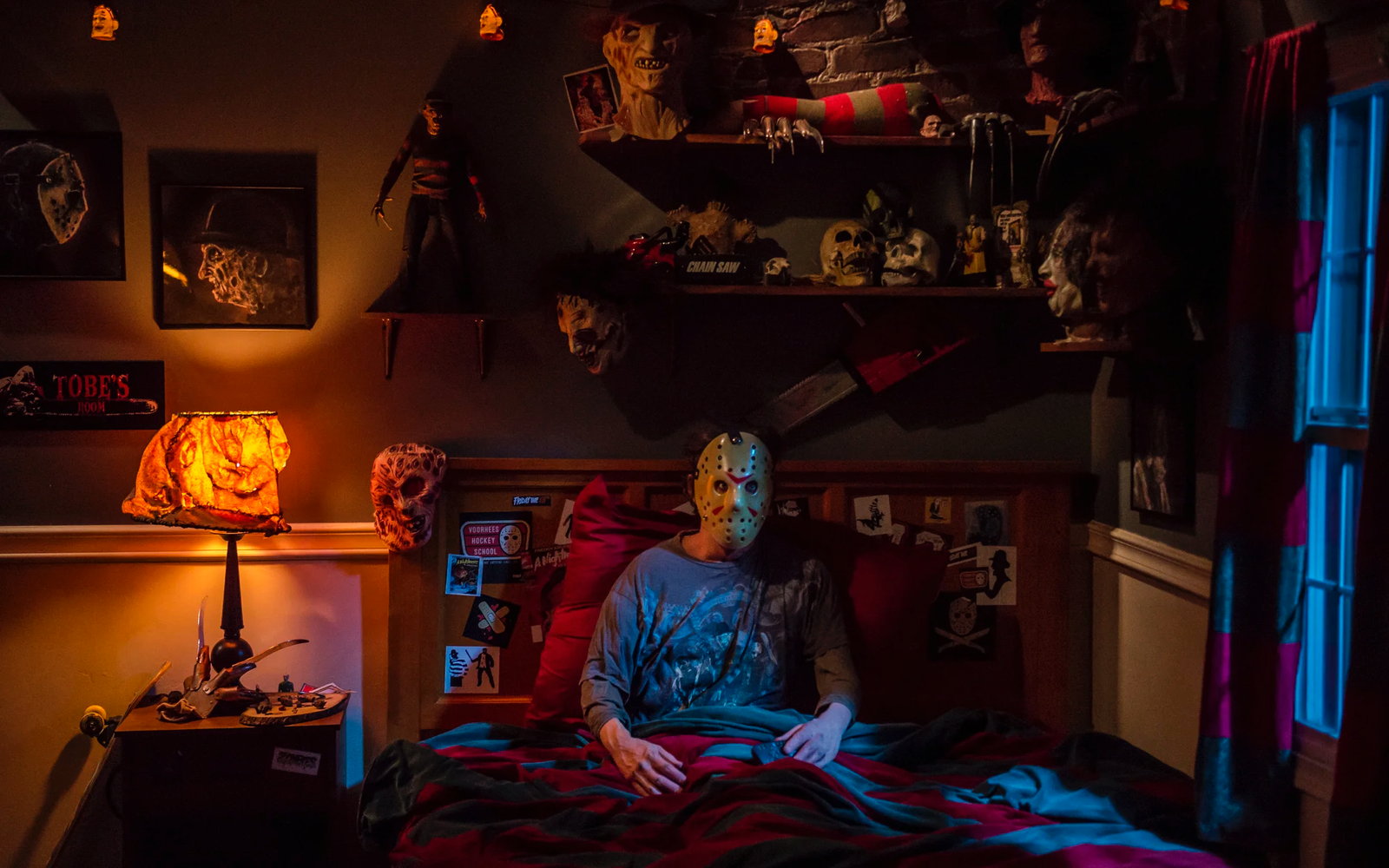 Scary Halloween night at home with pumpkins, candles and a horror movie on TV